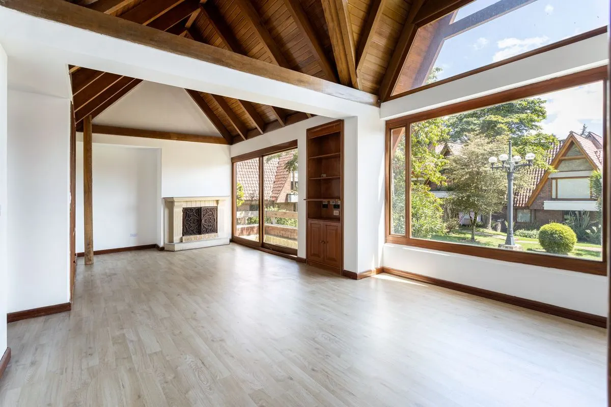 Bright living room with light wood floors, a wood ceiling and large windows