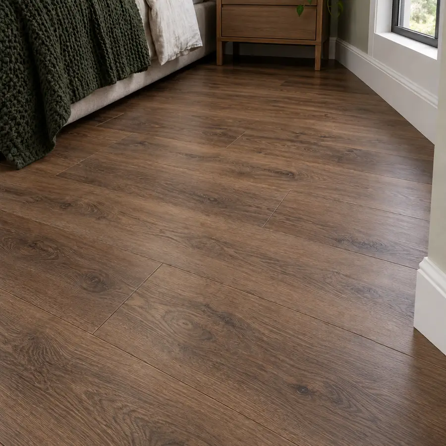 Wide-plank engineered hardwood floor in a warm brown oak finish in a cozy bedroom
